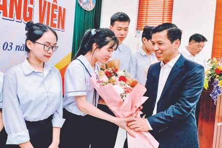 Phó Trưởng ban Tổ chức Thành ủy Hải Phòng Nguyễn Hồng Vinh tặng hoa các đảng viên mới là học sinh lớp 12 Trường THPT chuyên Trần Phú được kết nạp Đảng.