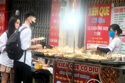 Một quầy bán thức ăn chế biến sẵn trên vỉa hè tại quận Hà Ðông (thành phố Hà Nội).