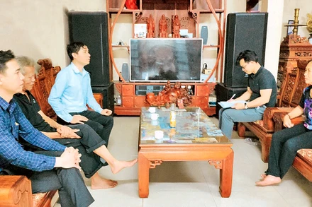 Cán bộ Mặt trận Tổ quốc xã Hồng Hà (huyện Ðan Phượng) vận động các hộ dân đồng thuận thực hiện giải phóng mặt bằng phục vụ thi công dự án. (Ảnh MINH PHÚ) 