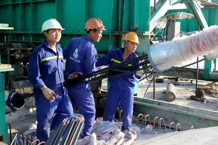 Công nhân lắp đặt thiết bị thông tin tại Nhà máy đóng tàu Hồng Hà (Hải Phòng). (Ảnh ANH SƠN)