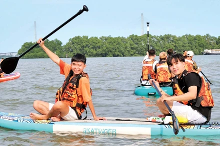 Du khách trải nghiệm chèo SUP trên sông Hậu. 