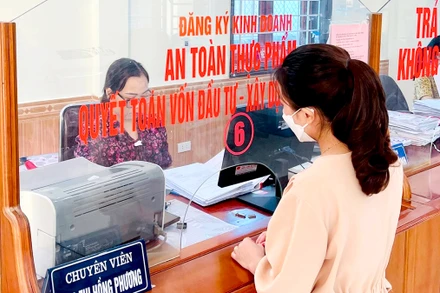Công chức Bộ phận một cửa huyện Nghi Lộc (Nghệ An) giải quyết thủ tục hành chính cho người dân.