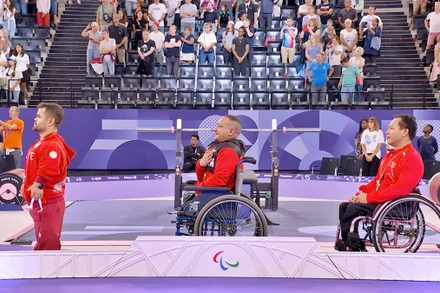 Lê Văn Công (bìa phải) nhận Huy chương đồng tại Paralympic 2024. (Ảnh NHƯ THUẬT)