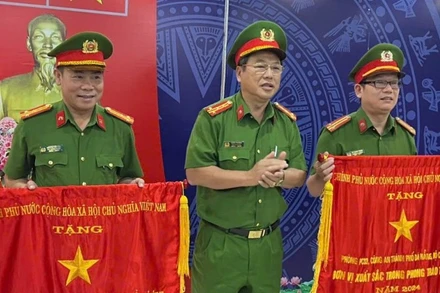 Thừa ủy quyền của Thủ tướng Chính phủ, Đại tá Trần Phòng, Phó Giám đốc Công an thành phố Đà Nẵng trao Cờ thi đua cho hai tập thể. (Ảnh: ANH ĐÀO)