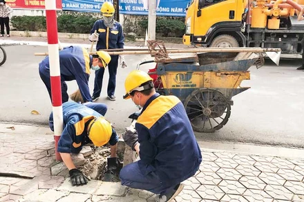 Công nhân Công ty Thoát nước Hà Nội nạo vét hệ thống thoát nước.