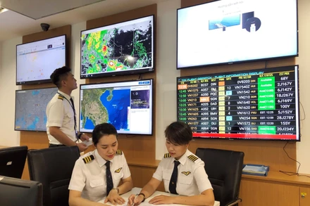 Cơ trưởng máy bay A350 Nguyễn Ly Hương (bên phải) trao đổi, chia sẻ kinh nghiệm bay với đồng nghiệp.