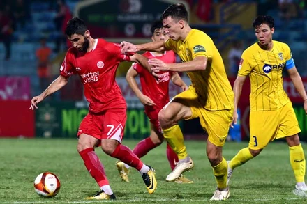Pha bóng giữa cầu thủ đội Viettel FC (áo đỏ) và đội Sông Lam Nghệ An. (Ảnh TRẦN HẢI)
