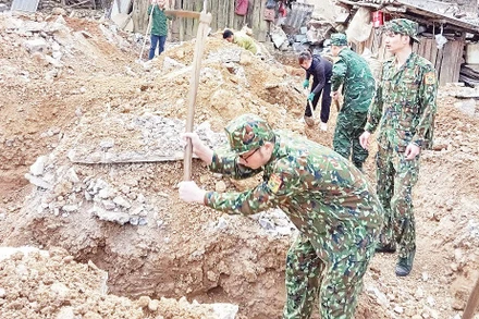 Cán bộ, chiến sĩ Đồn Biên phòng Cửa khẩu Sóc Giang giúp người dân xóm Mã Lịp, xã Trường Hà, huyện Hà Quảng (Cao Bằng) xây mới nhà ở.