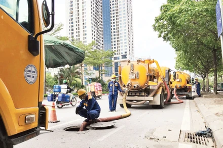 Công nhân Công ty Thoát nước Hà Nội nạo vét hệ thống thoát nước đô thị bằng thiết bị cơ giới.