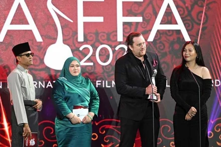 Đạo diễn Aaron Toronto và biên kịch Nhã Uyên lên sân khấu nhận giải thay cho Kim B. (Ảnh do Đoàn phim cung cấp)