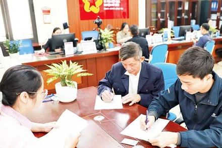 Người dân làm thủ tục cấp đổi giấy phép lái xe tại bộ phận một cửa của Ủy ban nhân dân huyện Mỹ Đức.