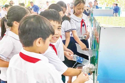 Các em học sinh phân loại rác trước khi bỏ vào xe.