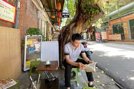 Lê Kiên Trung cùng cuốn The Hanoi Digest của anh.
