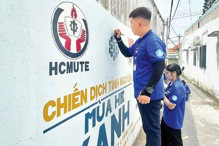 Các chiến sĩ Mùa hè xanh sơn sửa và vẽ tranh cổ động trên bức tường ở Khu phố 4, phường Tăng Nhơn Phú.