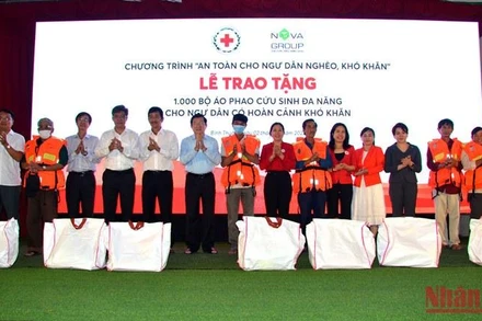 Nguyên Chủ tịch nước Trương Tấn Sang cùng đại diện Trung ương Hội Chữ Thập đỏ Việt Nam, lãnh đạo tỉnh Bình Thuận và nhà tài trợ trao tặng áo phao cứu sinh đa năng cho ngư dân Mũi Né, thành phố Phan Thiết (Bình Thuận).