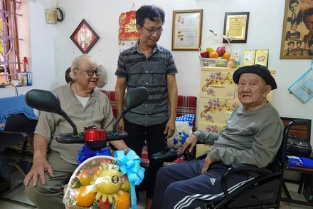 Nghệ sĩ Ưu tú Hùng Minh (bìa trái) vui mừng khi được tặng xe điện.