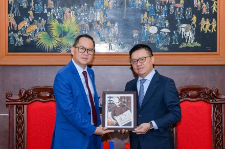 Tổng Biên tập Báo Nhân Dân Lê Quốc Minh tặng quà lưu niệm Chủ tịch Câu lạc bộ các nhà báo Campuchia Puy Kea. Ảnh: Thế Đại