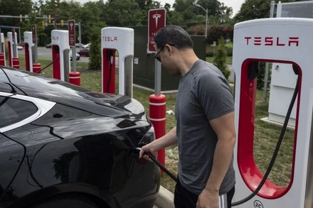 Người dân sạc điện cho ô-tô tại một trạm sạc của Tesla ở Arlington, Virginia, Mỹ. (Ảnh: AFP/TTXVN)