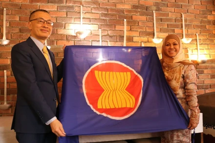 Đại sứ Việt Nam Vũ Quang Minh trao cờ ASEAN và chuyển giao vai trò Chủ tịch luân phiên Ủy ban ASEAN tại Berlin (BAC) cho Đại sứ Brunei Pengiran Krtini Pengiran Tahir. (Ảnh: Thu Hằng/TTXVN)