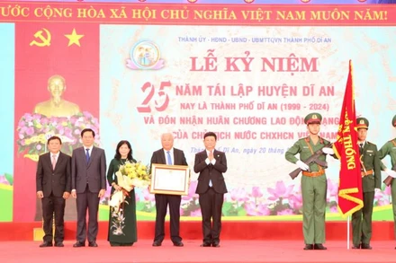 Thừa ủy nhiệm, Chủ tịch Ủy ban nhân dân tỉnh Bình Dương Võ Văn Minh trao Huân chương Lao động hạng Nhất cho Đảng bộ, chính quyền và nhân dân thành phố Dĩ An.