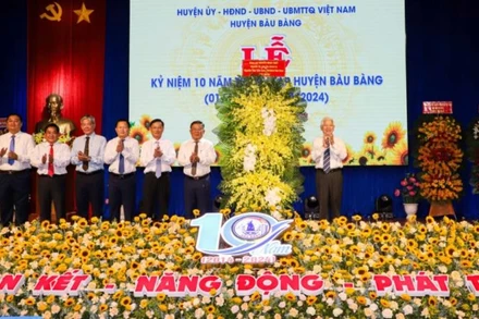 Nguyên Chủ tịch nước Nguyễn Minh Triết trao tặng lẵng hoa chúc mừng huyện Bàu Bàng. 