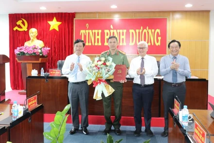 Thường trực Tỉnh ủy Bình Dương trao Quyết định của Ban Bí thư Trung ương Đảng và tặng hoa cho Đại tá Tạ Văn Đẹp.