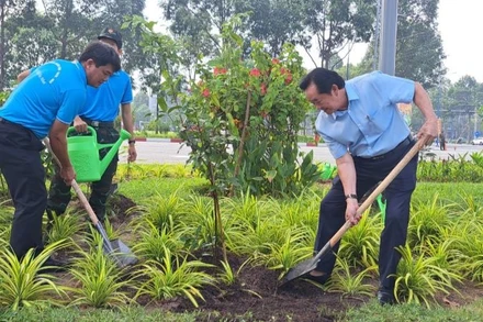Phó Bí thư Thường trực Tỉnh ủy Bình Dương Nguyễn Hoàng Thao (bên phải) trồng cây xanh tại lễ phát động.