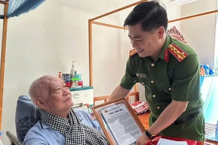 Đại tá Ngô Xuân Phú, Phó Giám đốc Công an tỉnh Bình Dương trao thư cám ơn đến thân nhân liệt sĩ phối hợp trong hoạt động thu, nhận mẫu ADN.