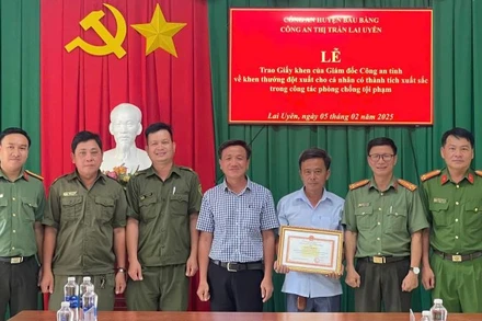 Thừa ủy quyền, đại diện Công an tỉnh Bình Dương trao tặng Giấy khen của Giám đốc Công an tỉnh cho ông Nguyễn Tấn Đức. 