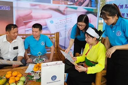 Cán bộ, nhân viên Bảo hiểm xã hội truyền thông bảo hiểm y tế tới người dân vùng thượng du Thanh Hóa.