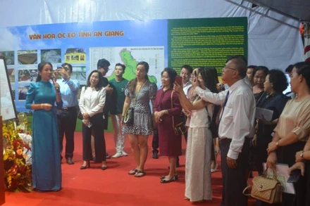 Du khách nghe nhân viên Bảo tàng tỉnh An Giang thuyết minh các bảo vật quốc gia tại An Giang.