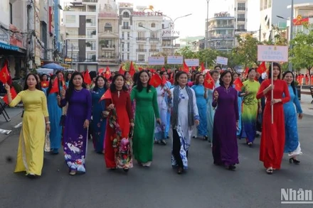 Các đại biểu diễu hành áo dài trên đường phố.
