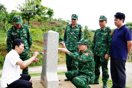 Đoàn công tác và Đồn biên phòng Chiềng On sơn sửa lại mốc quốc giới 230.