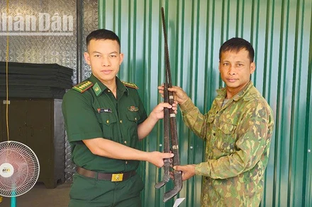 Cán bộ Đồn Biên phòng Mường Cai tiếp nhận 2 khẩu súng tự chế.