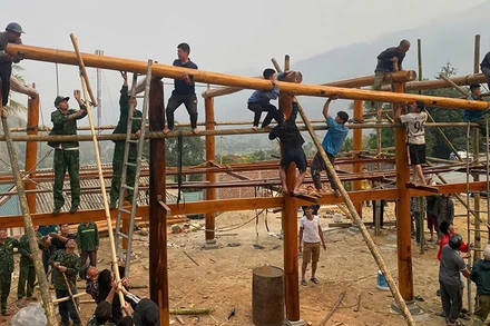 Các lực lượng trợ giúp hộ dân ở khu phố Tén Tằn xây lắp ngôi nhà sàn.