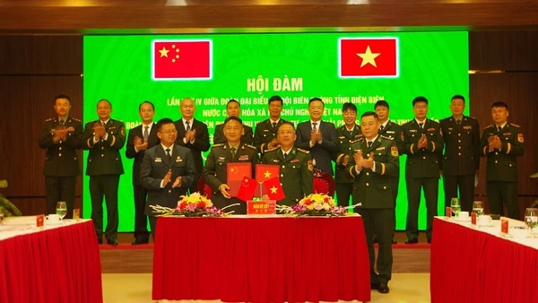 Đại diện Đoàn đại biểu Bộ đội Biên phòng tỉnh Điện Biên và Đoàn đại biểu Bộ đội Biên phòng khu vực Mông Tự trao biên bản ký kết tại hội đàm.