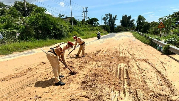 Lực lượng cảnh sát giao thông đang dọn cát.