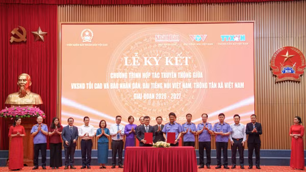 Đồng chí Nguyễn Huy Tiến, Viện trưởng Kiểm sát nhân dân tối cao và đồng chí Lê Quốc Minh, Tổng Biên tập Báo Nhân Dân thực hiện nghi thức ký kết giữa Viện Kiểm sát nhân dân tối cao với Báo Nhân Dân. (Ảnh: QUANG MINH)