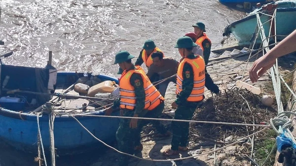 Bộ đội biên phòng hỗ trợ ngư dân kéo tàu lên.