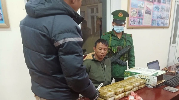 Đối tượng Thào A Pháng (người giữa) cùng tang vật khi bị Bộ đội Biên phòng tỉnh Điện Biên bắt giữ. 