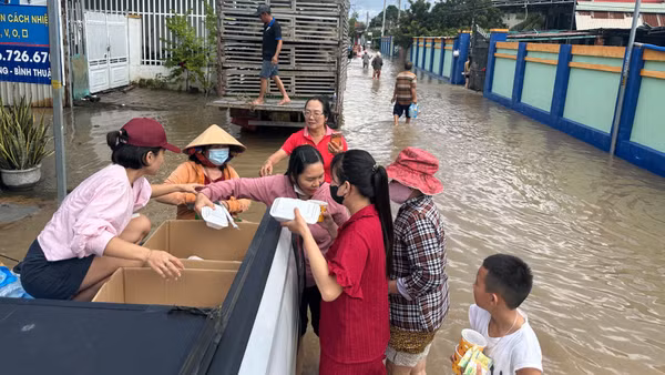 Các nhóm tình nguyện phát cơm giữa dòng lũ.