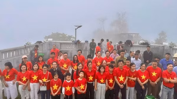 Du khách và nhân dân xã Sín Thầu thực hiện nghi lễ chào cờ dưới chân Cột cờ A Pa Chải trong Ngày Quốc tế Lao động 1/5.