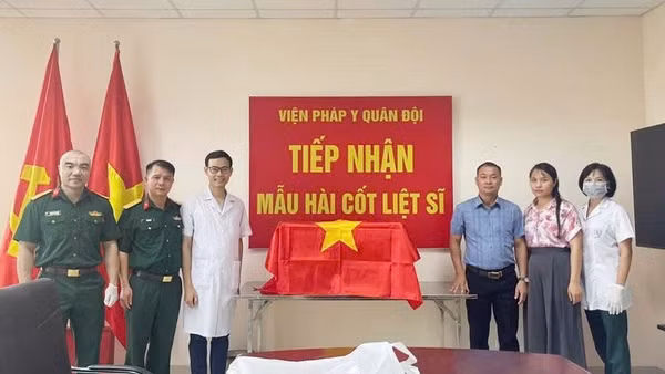 Thành viên Ban Chỉ đạo tìm kiếm, xác định danh tính liệt sĩ tỉnh Điện Biên bàn giao mẫu hài cốt liệt sĩ cho Viện Pháp y Quân đội. (Ảnh: ĐỨC HẠNH)