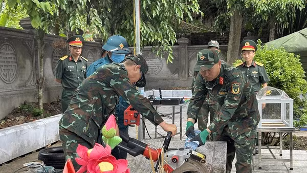 Lực lượng chức năng tiến hành việc lấy mẫu trên phần mộ liệt sĩ tại nghĩa trang liệt sĩ Tuần Giáo. 
