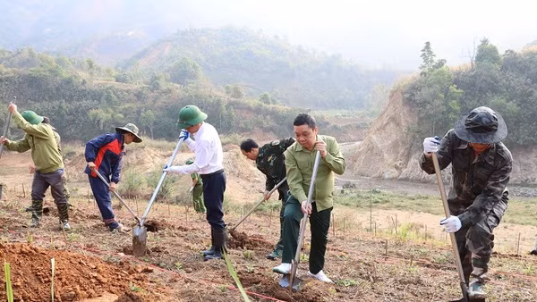 Các đồng chí lãnh đạo cùng nhân dân xã Na Son hưởng ứng Lễ phát động đào hố trồng cây mắc-ca, cà-phê trên địa bàn.