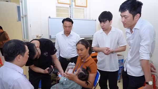 Đồng chí Phạm Giang Nam, Giám đốc Sở Y tế Điện Biên thăm, động viên trẻ em trước khi được bác sĩ phẫu thuật. Ảnh: BÍCH DUYÊN