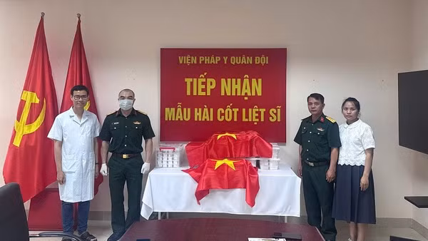 Đại diện Ban Chỉ đạo tìm kiếm, xác định danh tính liệt sĩ tỉnh Điện Biên bàn giao mẫu hài cốt liệt sĩ cho Viện Pháp y Quân đội. (Ảnh: ĐỨC HẠNH)