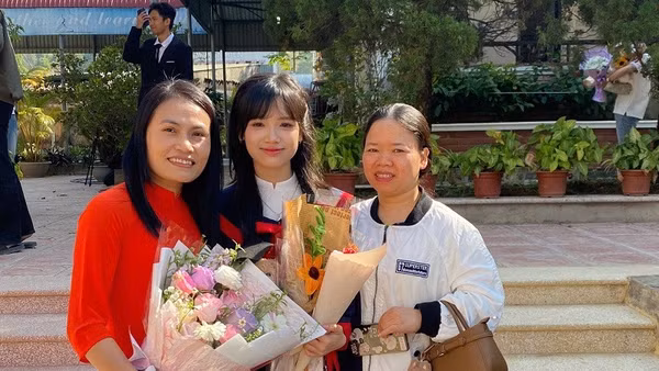 Đặng Quỳnh Trang trong vòng tay yêu thương của mẹ và cô giáo chủ nhiệm Bùi Thị Thu Hà.