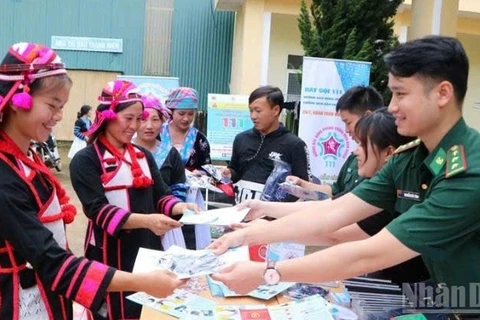 Phát tờ rơi tuyên truyền nhằm nâng cao nhận thức về phòng, chống mua bán người ở biên giới Lai Châu.(Ảnh: Bộ đội Biên phòng)
