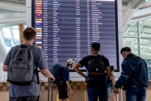 Hành khách xem thông tin trên bảng điện tử tại sân bay quốc tế I Gusti Ngurah Rai ở Bali, Indonesia. (Ảnh: XINHUA)